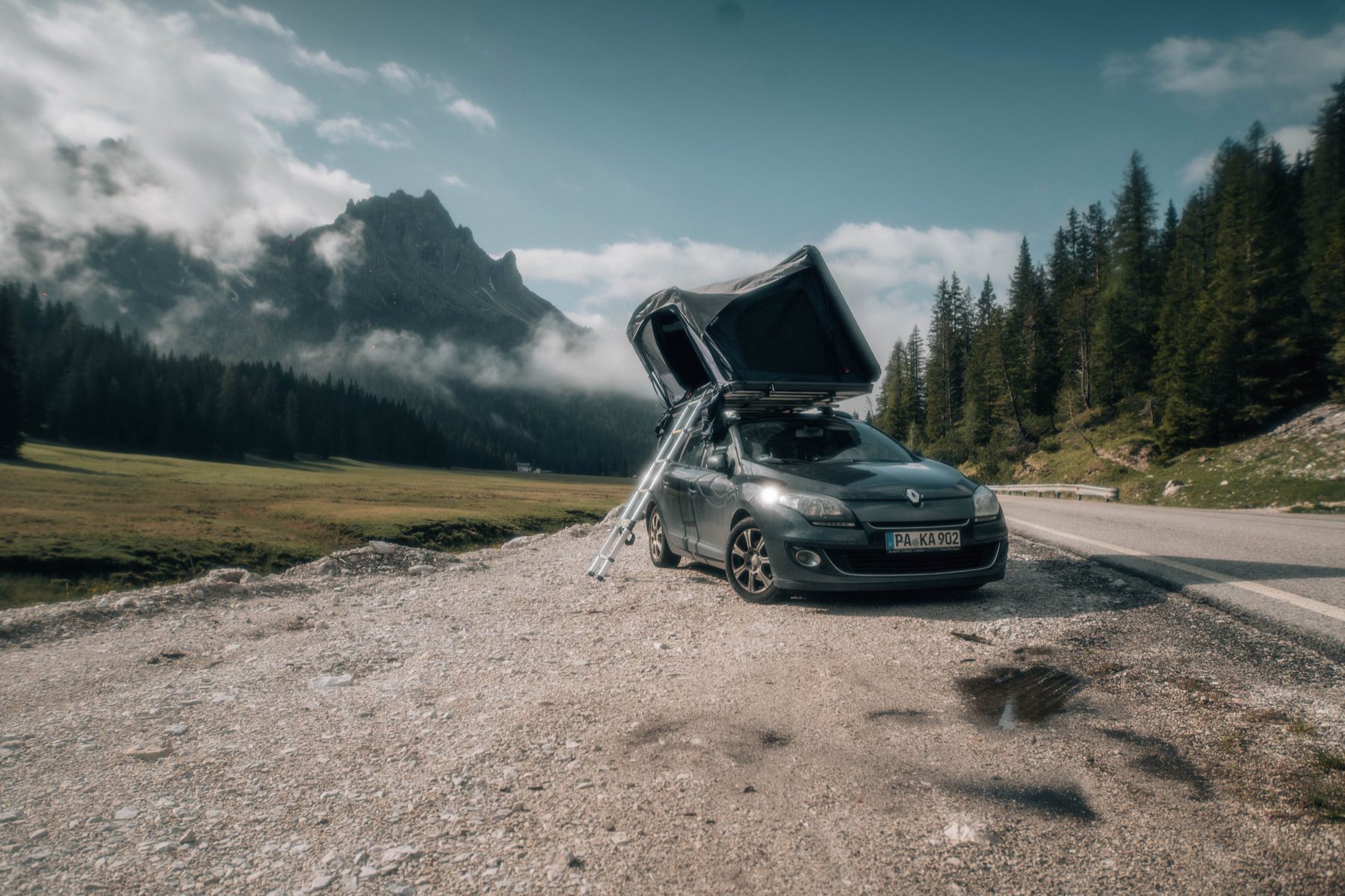 Auto mit aufgeklapptem Dachzelt in der Natur